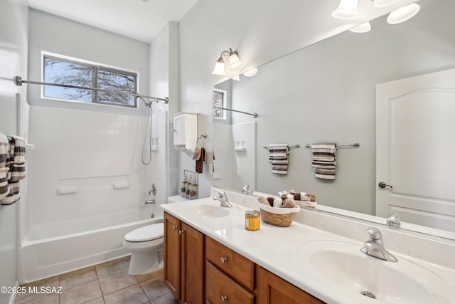 bathroom featuring tile patterned floors, washtub / shower combination, a sink, and toilet