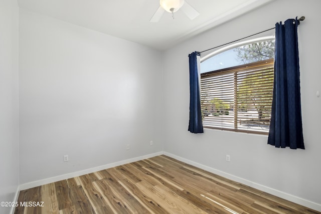 empty room with wood finished floors, baseboards, and ceiling fan
