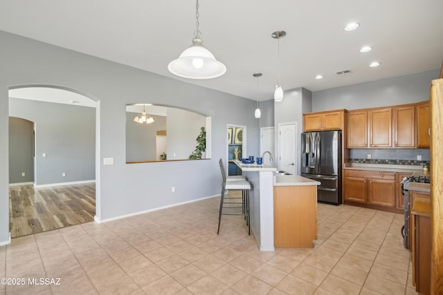 kitchen featuring visible vents, arched walkways, appliances with stainless steel finishes, and tasteful backsplash