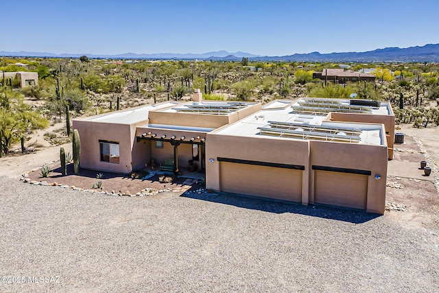4247 W Flying Diamond Dr, Tucson, AZ 85742 - pueblo revival-style home with driveway, a mountain view, an attached garage, and stucco siding