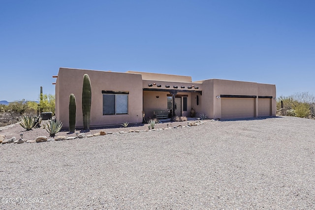 4247 W Flying Diamond Dr, Tucson, AZ 85742 - pueblo-style home with stucco siding, driveway, and an attached garage