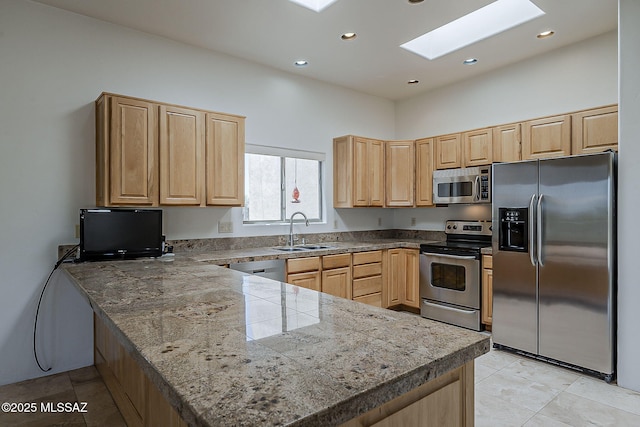 4247 W Flying Diamond Dr, Tucson, AZ 85742 - kitchen with a sink, appliances with stainless steel finishes, light brown cabinets, a peninsula, and a skylight