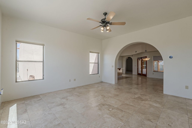 4247 W Flying Diamond Dr, Tucson, AZ 85742 - unfurnished room with arched walkways, ceiling fan, and plenty of natural light
