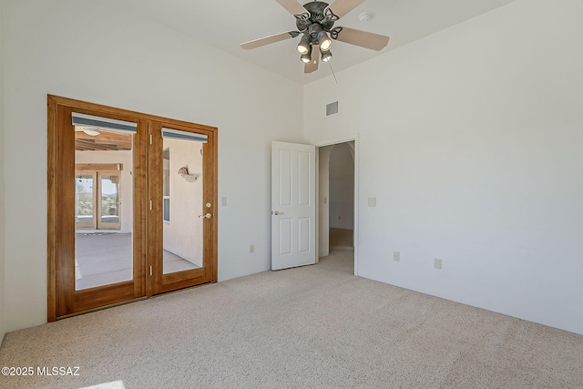 4247 W Flying Diamond Dr, Tucson, AZ 85742 - unfurnished bedroom with light colored carpet, visible vents, access to exterior, a towering ceiling, and a ceiling fan