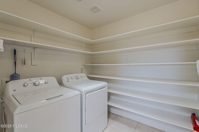 4247 W Flying Diamond Dr, Tucson, AZ 85742 - laundry room with washer and clothes dryer, visible vents, light tile patterned floors, and laundry area