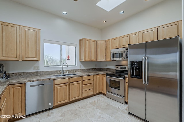 4247 W Flying Diamond Dr, Tucson, AZ 85742 - kitchen featuring a skylight, light brown cabinets, stainless steel appliances, a sink, and tile countertops