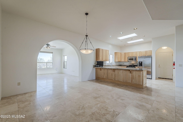 4247 W Flying Diamond Dr, Tucson, AZ 85742 - kitchen with arched walkways, a peninsula, light tile patterned floors, appliances with stainless steel finishes, and open floor plan