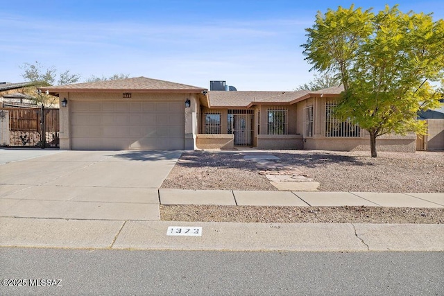 single story home with concrete driveway, an attached garage, fence, and stucco siding