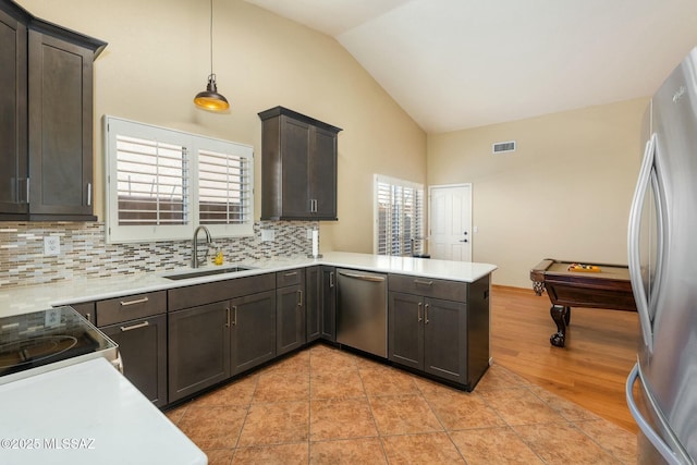 kitchen with stainless steel appliances, backsplash, light countertops, and a sink