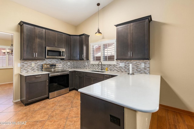 kitchen featuring light countertops, appliances with stainless steel finishes, decorative backsplash, and a sink