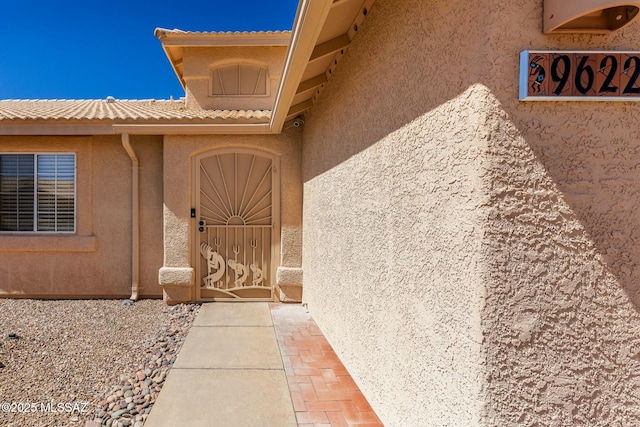 entrance to property featuring stucco siding