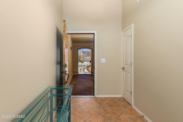 hall with baseboards and light tile patterned flooring