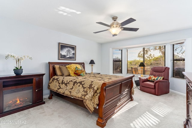 14045 N Desert Butte Dr, Oro Valley, AZ 85755 - bedroom featuring a glass covered fireplace, baseboards, multiple windows, and light carpet