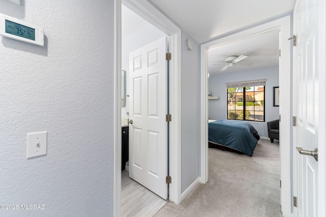 14045 N Desert Butte Dr, Oro Valley, AZ 85755 - corridor featuring baseboards, a textured wall, and light carpet