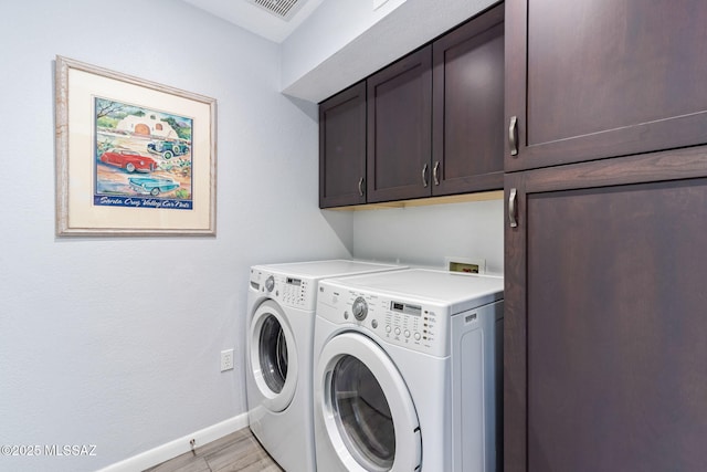 14045 N Desert Butte Dr, Oro Valley, AZ 85755 - laundry room with baseboards, light wood-style flooring, cabinet space, and washing machine and clothes dryer