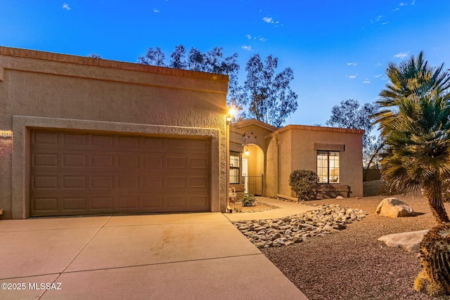 14045 N Desert Butte Dr, Oro Valley, AZ 85755 - view of front of house with a garage, stucco siding, and concrete driveway