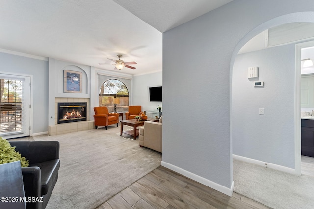 14045 N Desert Butte Dr, Oro Valley, AZ 85755 - living area with arched walkways, ceiling fan, baseboards, and a fireplace