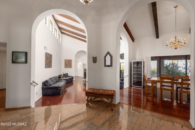 foyer featuring high vaulted ceiling, baseboards, beverage cooler, and beam ceiling