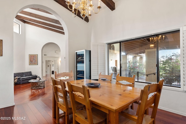 dining room featuring beamed ceiling, arched walkways, an inviting chandelier, and a wealth of natural light