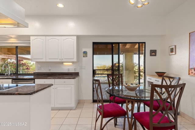 kitchen with recessed lighting, a sink, light tile patterned flooring, baseboards, and white cabinetry