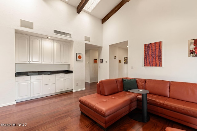 living area with high vaulted ceiling, beamed ceiling, wood finished floors, and visible vents