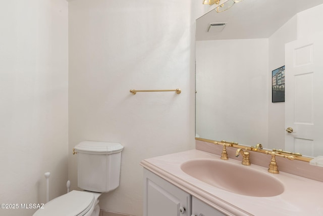 bathroom with visible vents, toilet, and vanity
