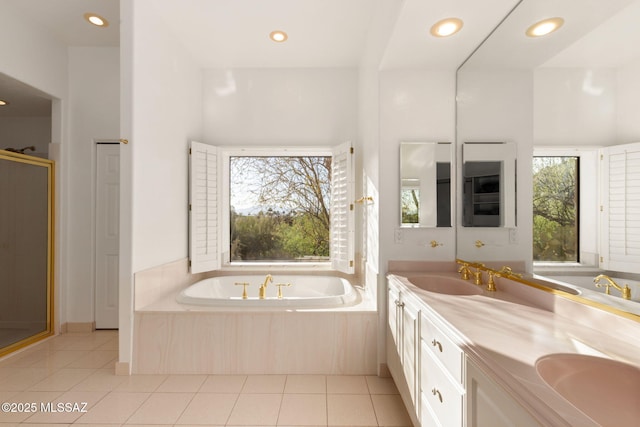 bathroom with recessed lighting, a garden tub, tile patterned floors, and a sink