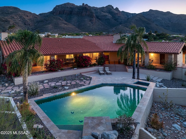 outdoor pool with a patio and a mountain view