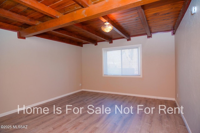 spare room featuring wood ceiling, wood finished floors, baseboards, and beam ceiling