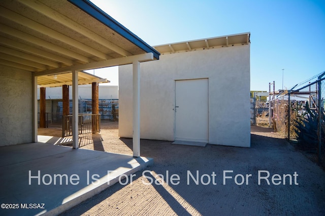 view of patio featuring fence and an outbuilding