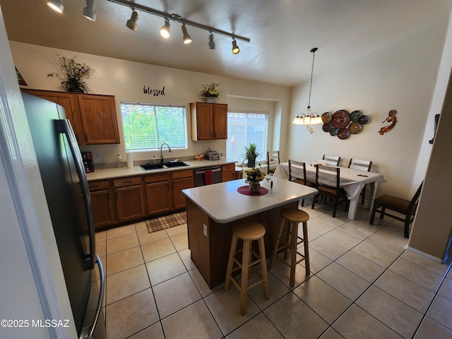 60464 E Blackcrest Loop, Tucson, AZ 85739 - kitchen with a sink, light countertops, a kitchen breakfast bar, freestanding refrigerator, and dishwashing machine