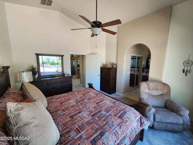 60464 E Blackcrest Loop, Tucson, AZ 85739 - bedroom featuring visible vents, arched walkways, high vaulted ceiling, freestanding refrigerator, and light carpet