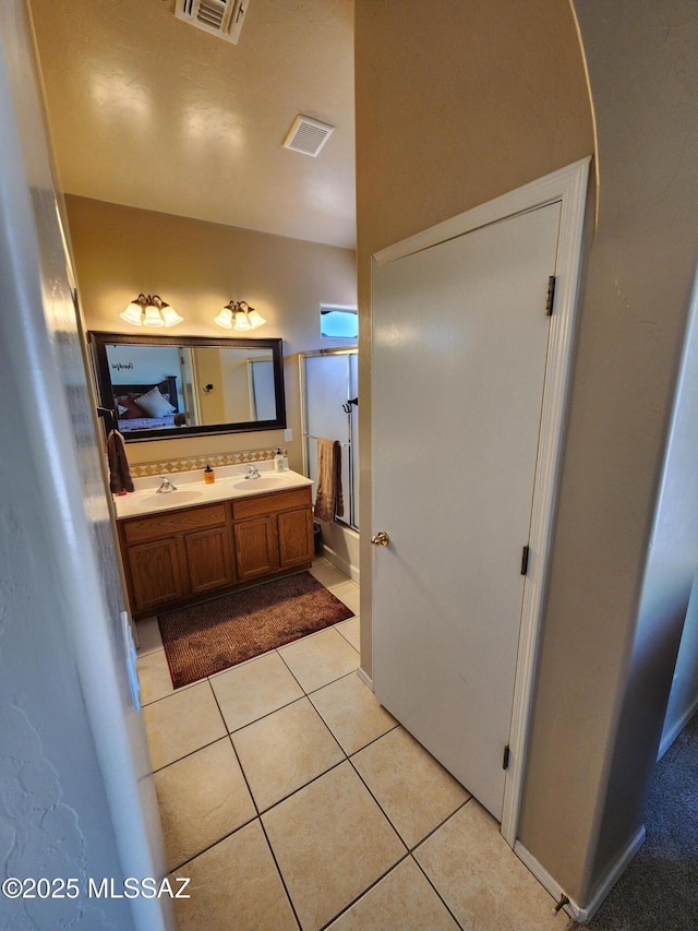 60464 E Blackcrest Loop, Tucson, AZ 85739 - ensuite bathroom featuring double vanity, tile patterned floors, visible vents, and a sink
