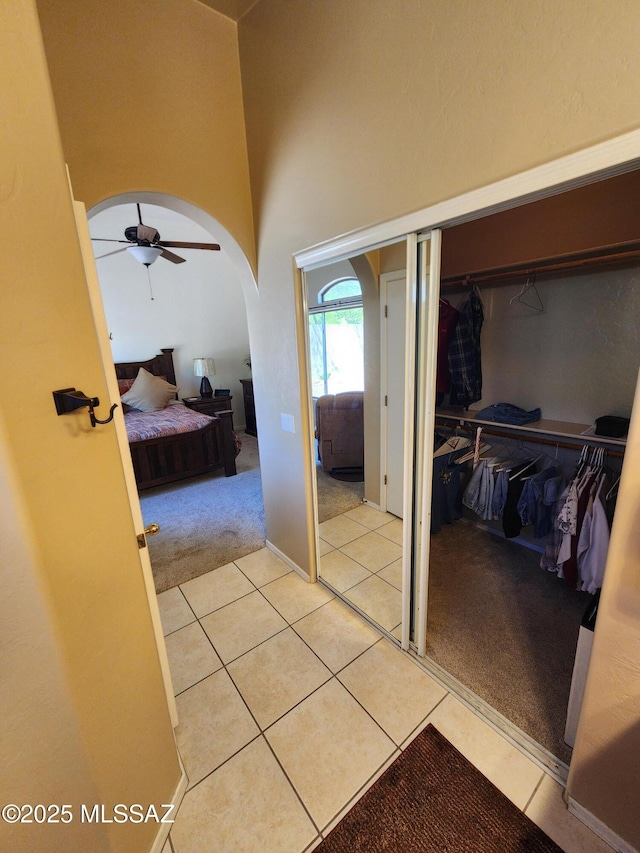 60464 E Blackcrest Loop, Tucson, AZ 85739 - interior space featuring a closet, a high ceiling, light colored carpet, arched walkways, and light tile patterned floors