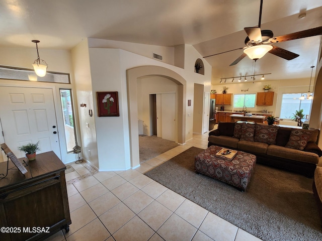60464 E Blackcrest Loop, Tucson, AZ 85739 - living room featuring light tile patterned flooring, ceiling fan, arched walkways, vaulted ceiling, and visible vents