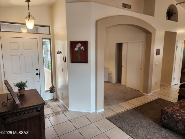 60464 E Blackcrest Loop, Tucson, AZ 85739 - entrance foyer with a high ceiling, arched walkways, baseboards, light tile patterned floors, and visible vents