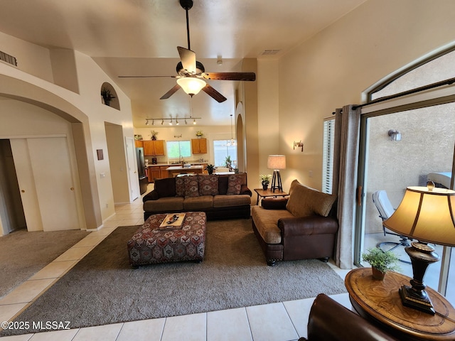 60464 E Blackcrest Loop, Tucson, AZ 85739 - living room with visible vents, ceiling fan, high vaulted ceiling, arched walkways, and light tile patterned floors