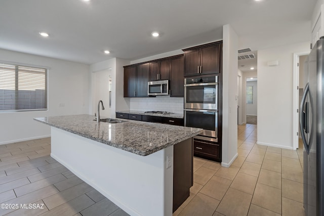 3352 W Shadow Park Way, Tucson, AZ 85742 - kitchen with appliances with stainless steel finishes, a sink, backsplash, dark brown cabinetry, and stone countertops