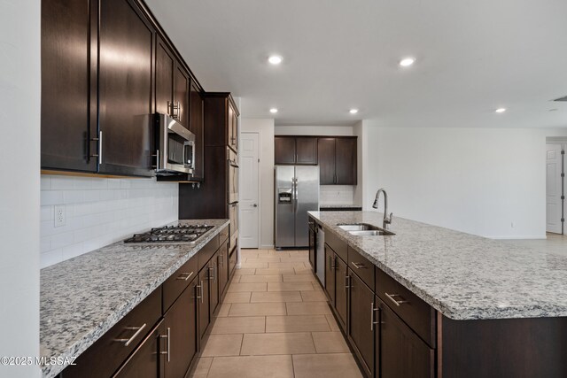 3352 W Shadow Park Way, Tucson, AZ 85742 - kitchen with stainless steel appliances, a sink, decorative backsplash, light stone counters, and dark brown cabinetry