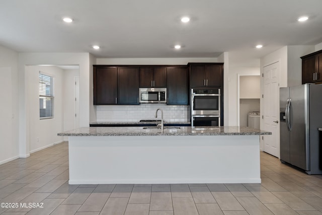 3352 W Shadow Park Way, Tucson, AZ 85742 - kitchen featuring stainless steel appliances, a sink, backsplash, light stone countertops, and dark brown cabinetry