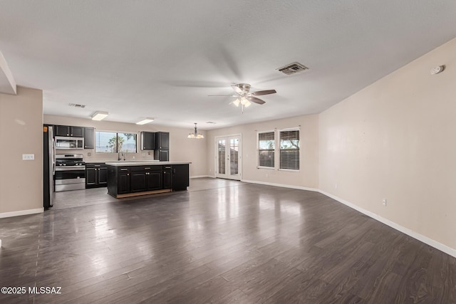 living room with baseboards, visible vents, and ceiling fan with notable chandelier