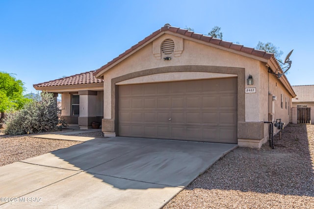 ranch-style home with stucco siding, a tile roof, driveway, and a garage