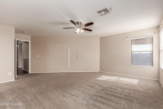 carpeted spare room with baseboards, a ceiling fan, and visible vents