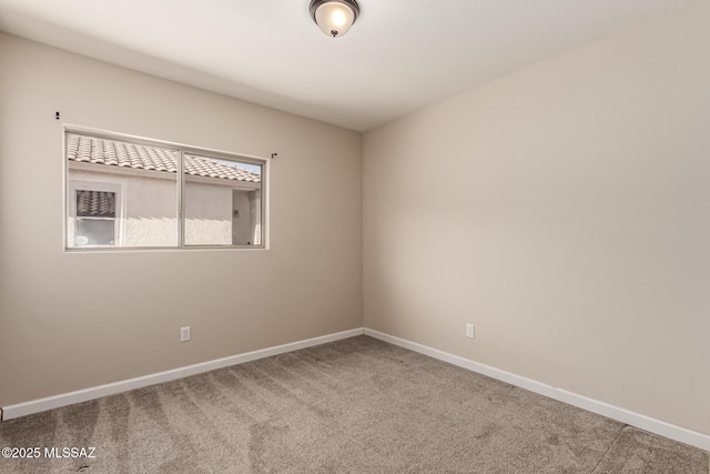 spare room with baseboards and carpet