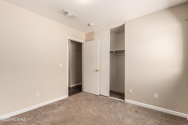 unfurnished bedroom featuring carpet floors, a closet, visible vents, and baseboards