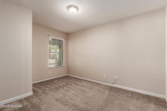 carpeted empty room featuring baseboards