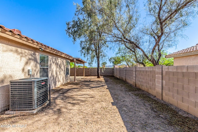 view of yard with a fenced backyard and central AC unit