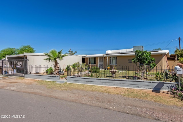 manufactured / mobile home featuring stucco siding and a fenced front yard