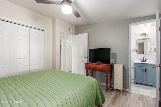 bedroom featuring a sink, a closet, ceiling fan, ensuite bath, and visible vents