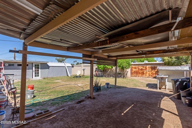 view of yard featuring fence, an outbuilding, and a shed